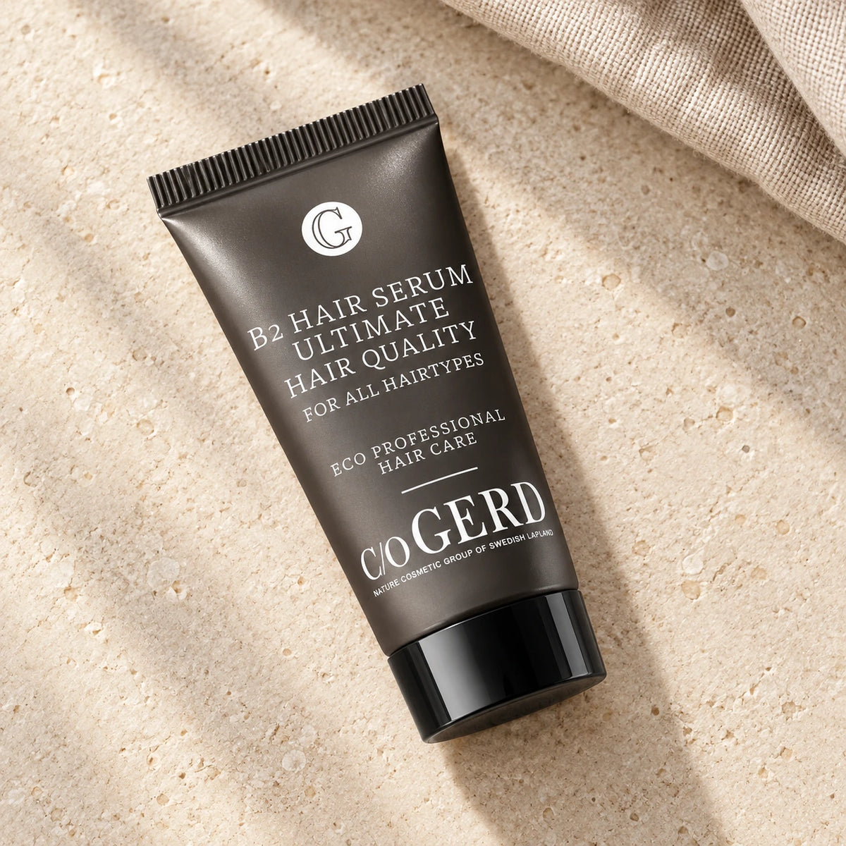 C/O Gerd B2 Hair Serum 30 ml liggande på ljus sten med en linnetextil i bakgrunden.